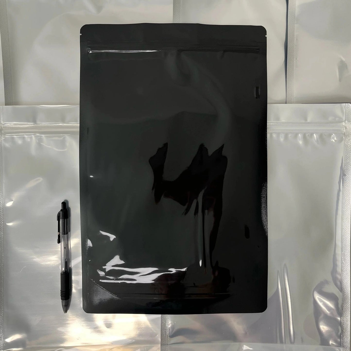 Black size Q mylar bag on top of other bags