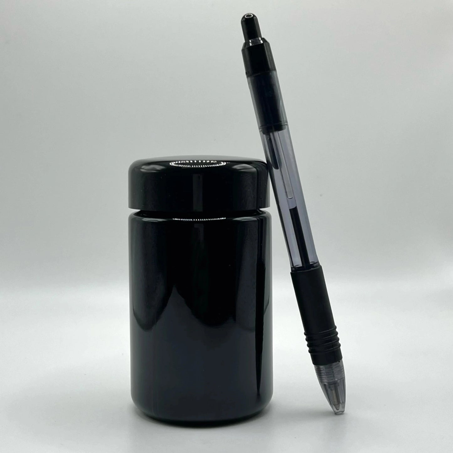 Black pen and black glass jar on a white background