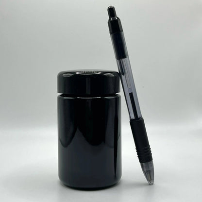 Black pen and black glass jar on a white background