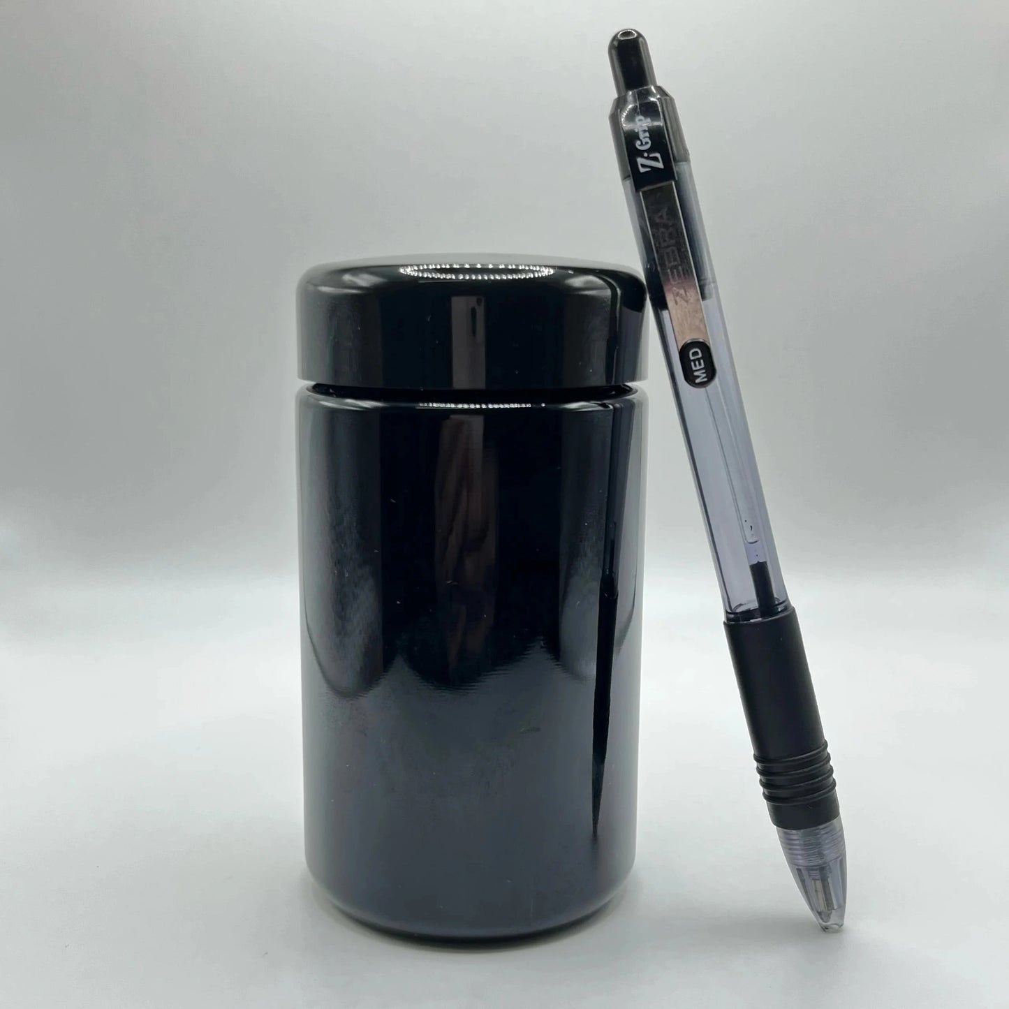 Black jar with a pen on a white background