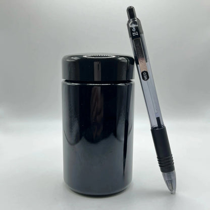 Black jar with a pen on a white background