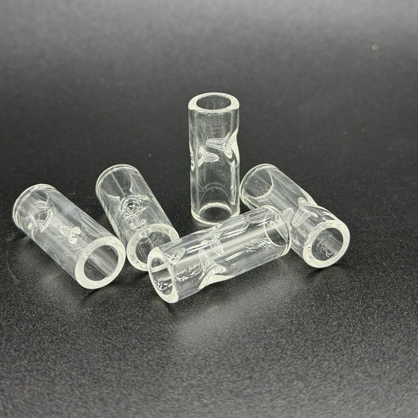 Clear plastic tubes with two pinches on a dark background