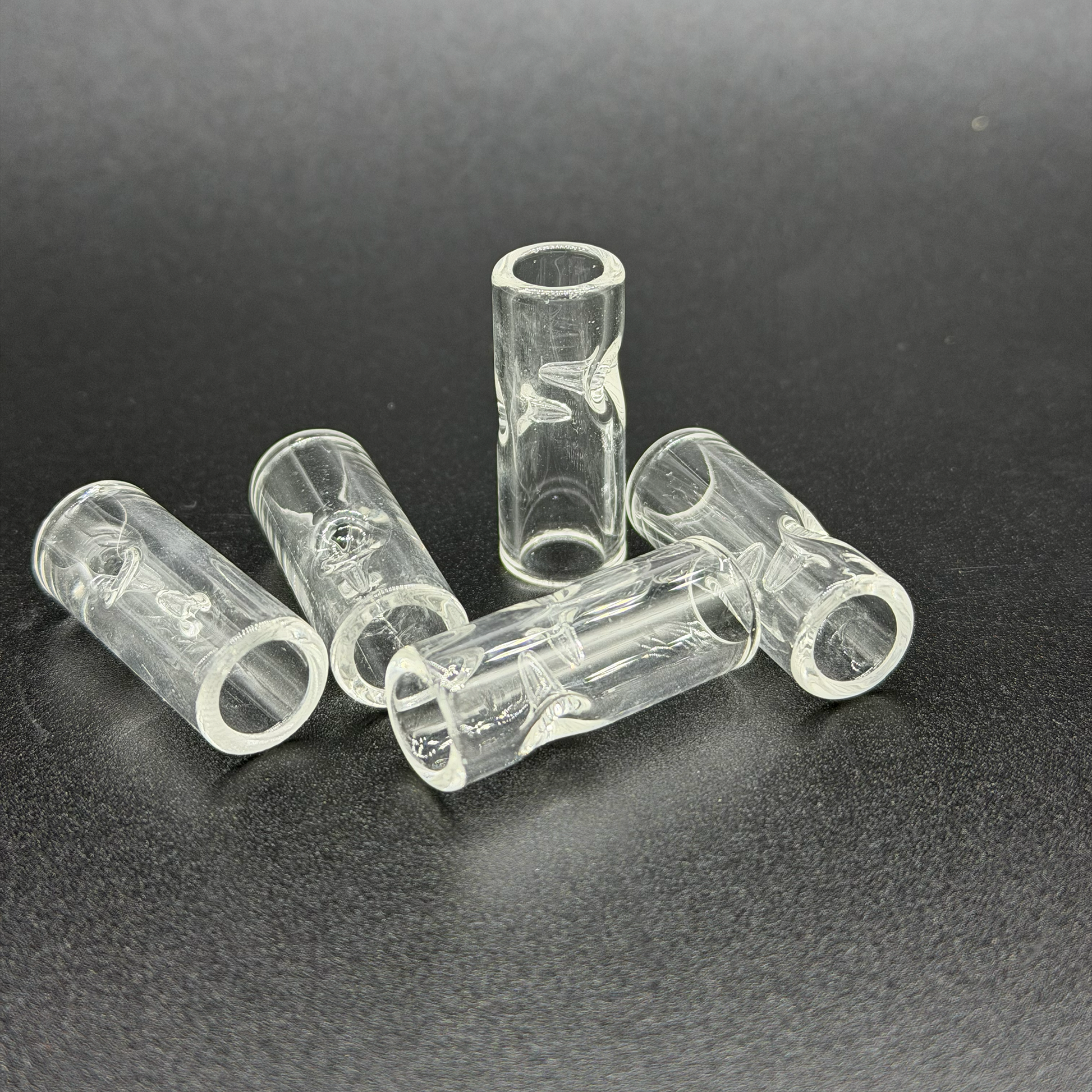 Clear plastic tubes with two pinches on a dark background