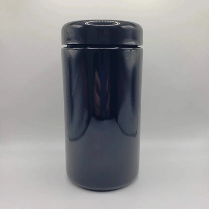 Black glass jar with a lid on a white background