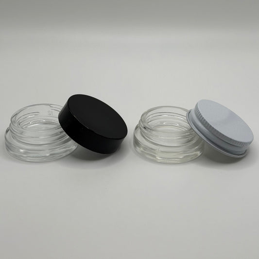 Two glass jars with black and white lids on a white background