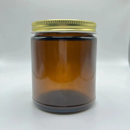 Amber glass jar with a gold lid on a white background