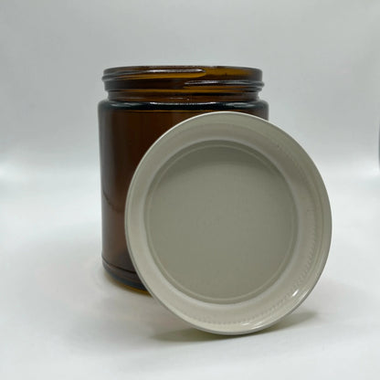 Amber glass jar with a white lid on a white background