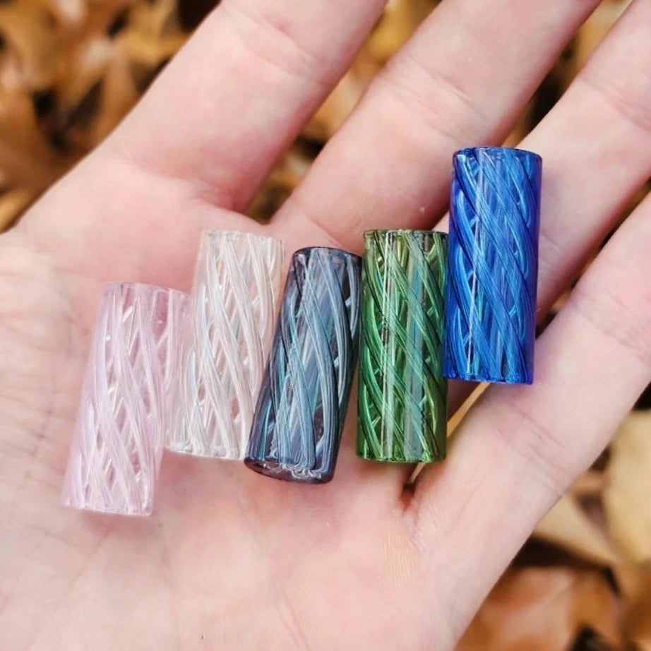 Four colorful glass tubes on a hand with a natural background