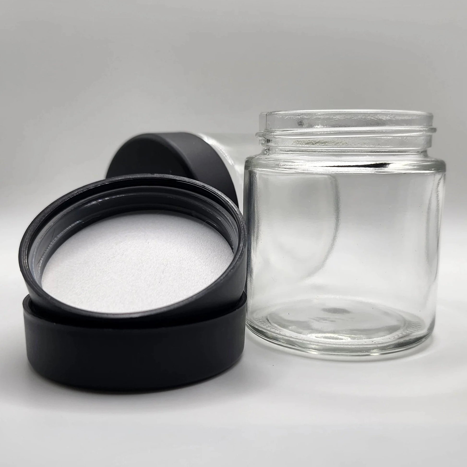Clear glass jar with black lid on a gray background