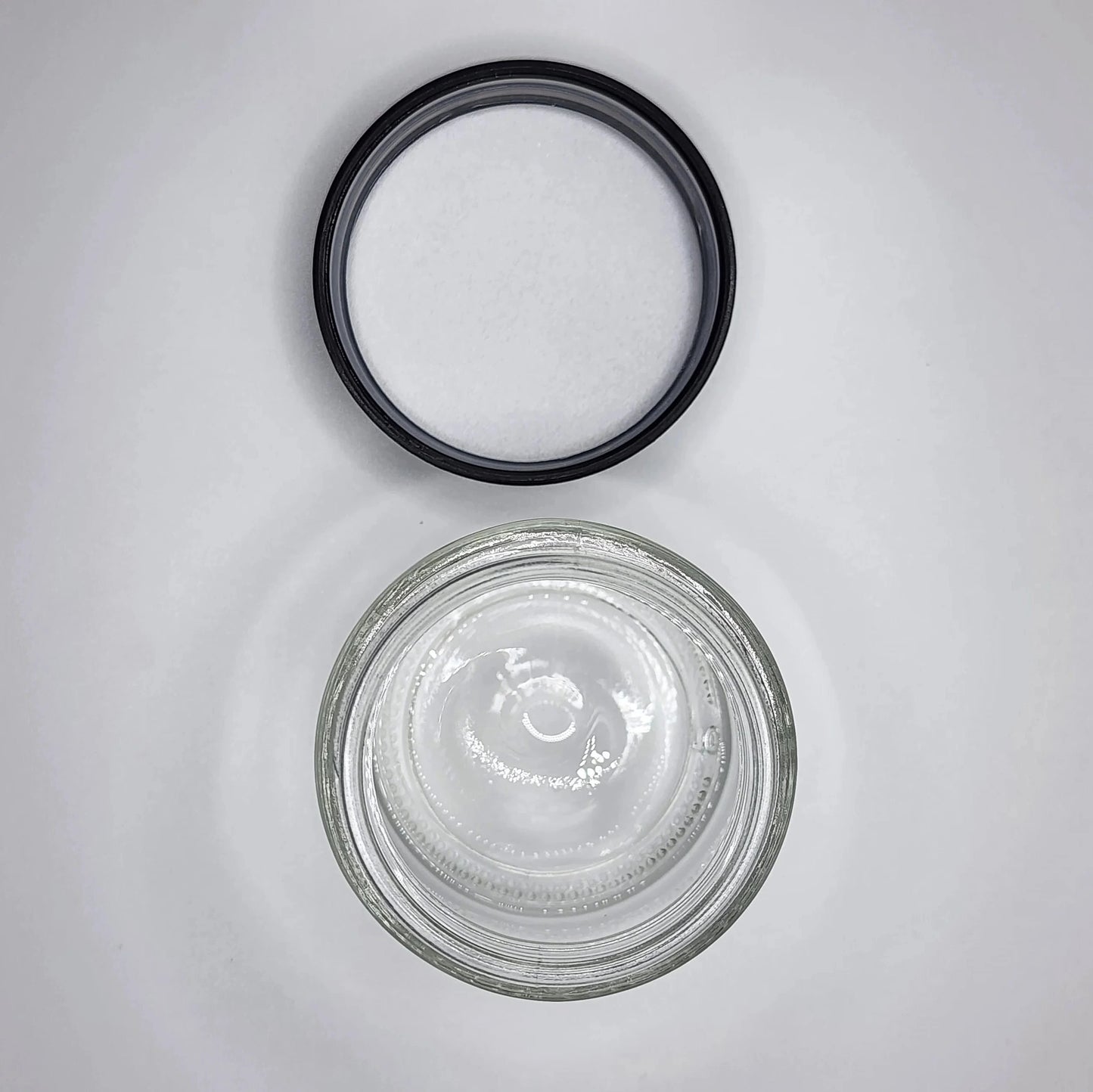 Glass jar with a black lid on a gray background