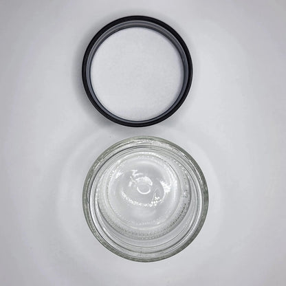 Glass jar with a black lid on a gray background