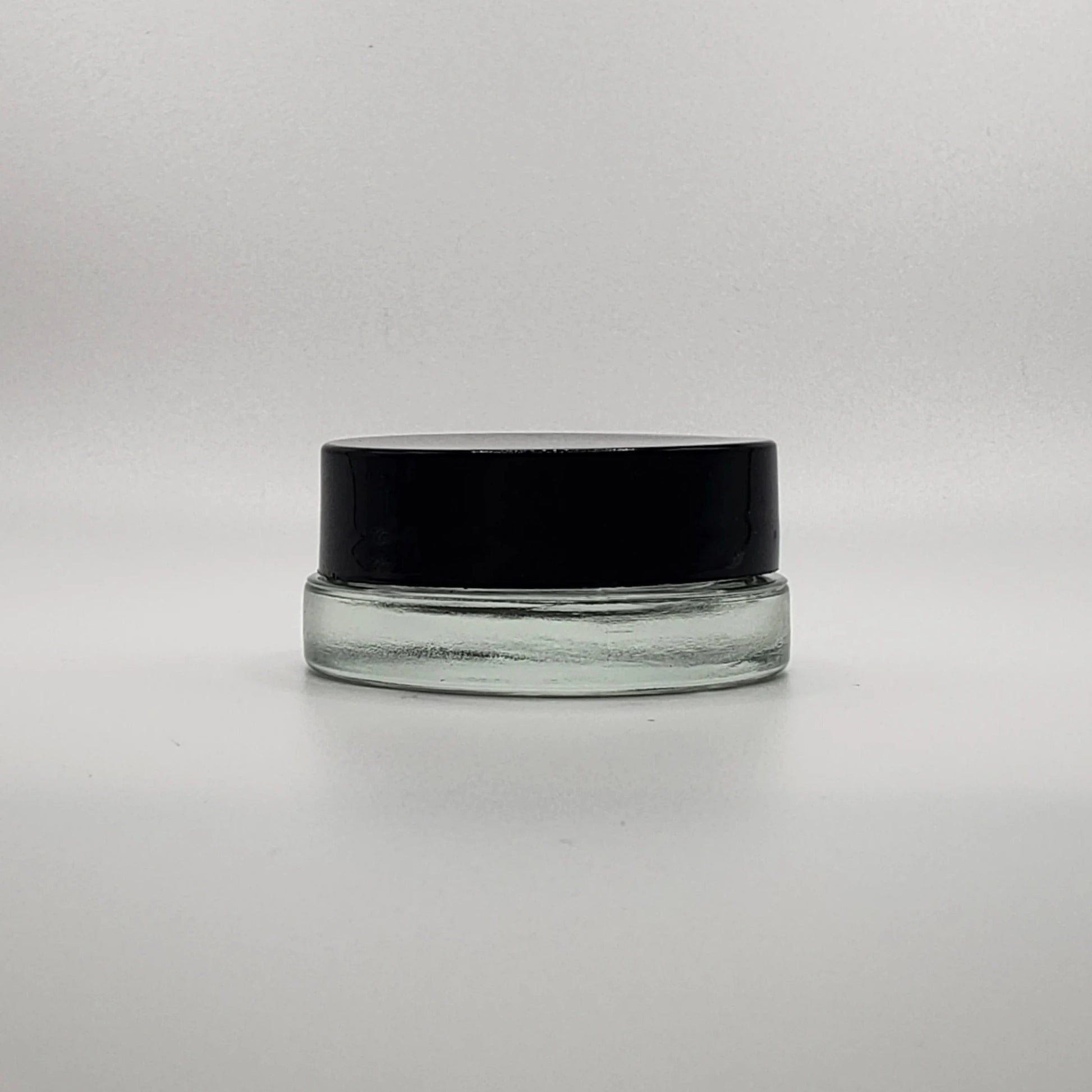 Clear glass jar with a black lid on a white background