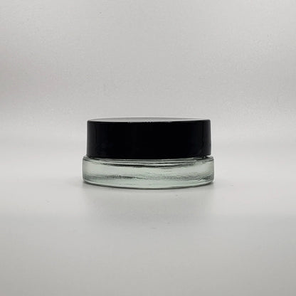 Clear glass jar with a black lid on a white background