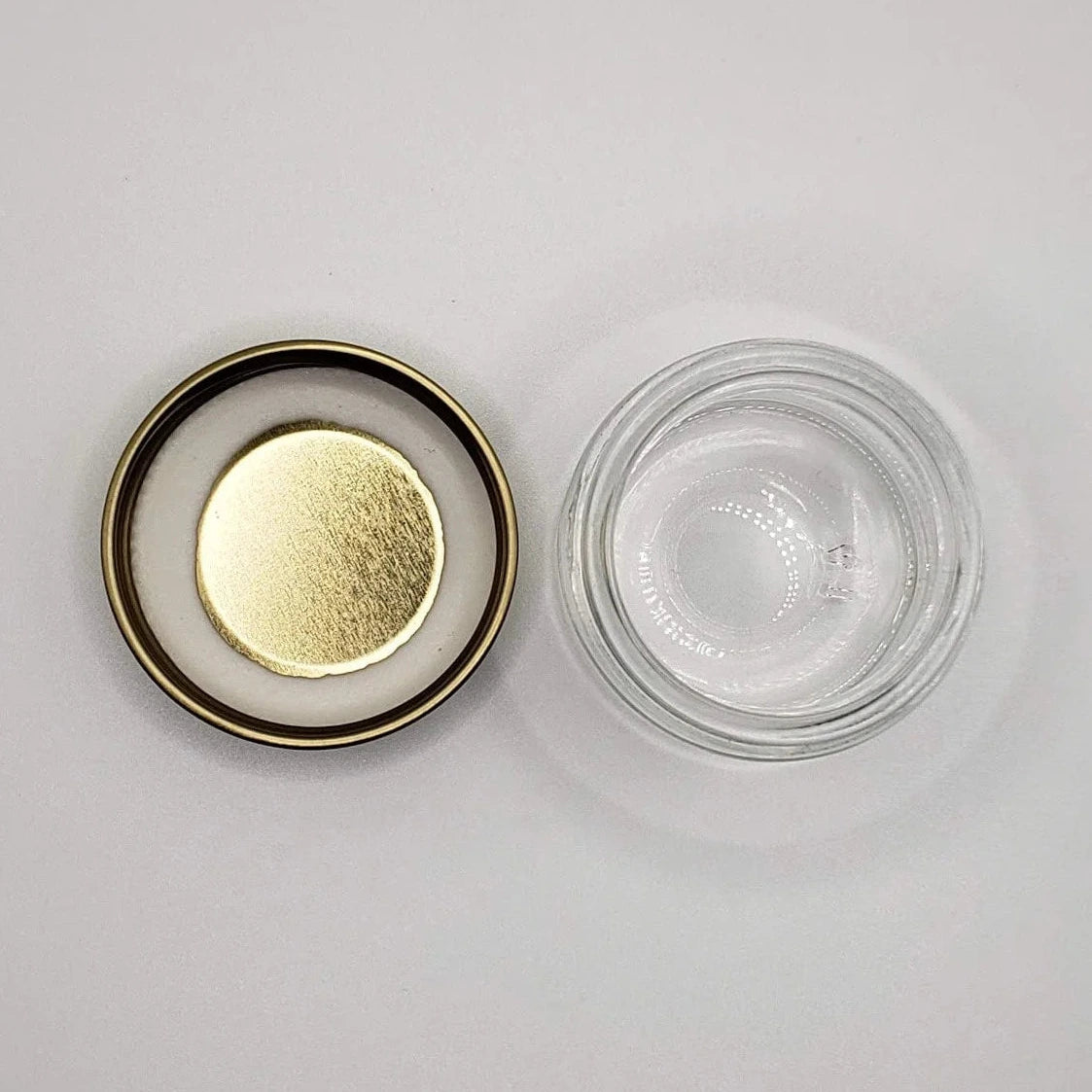 Glass jar with gold lid on a white background