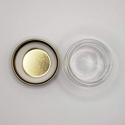 Glass jar with gold lid on a white background