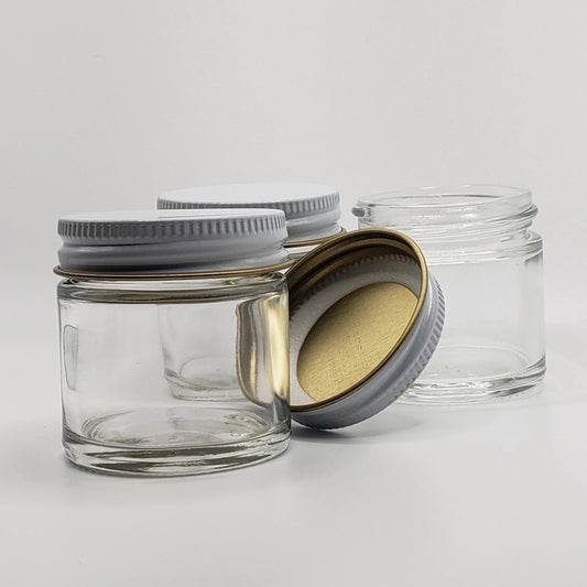 Clear glass jars with metal lids on a light gray background