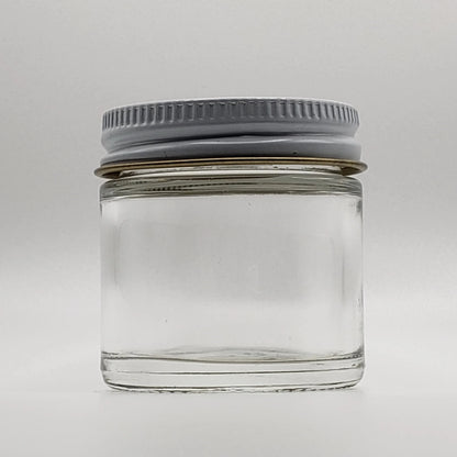 Clear glass jar with a gray lid on a white background