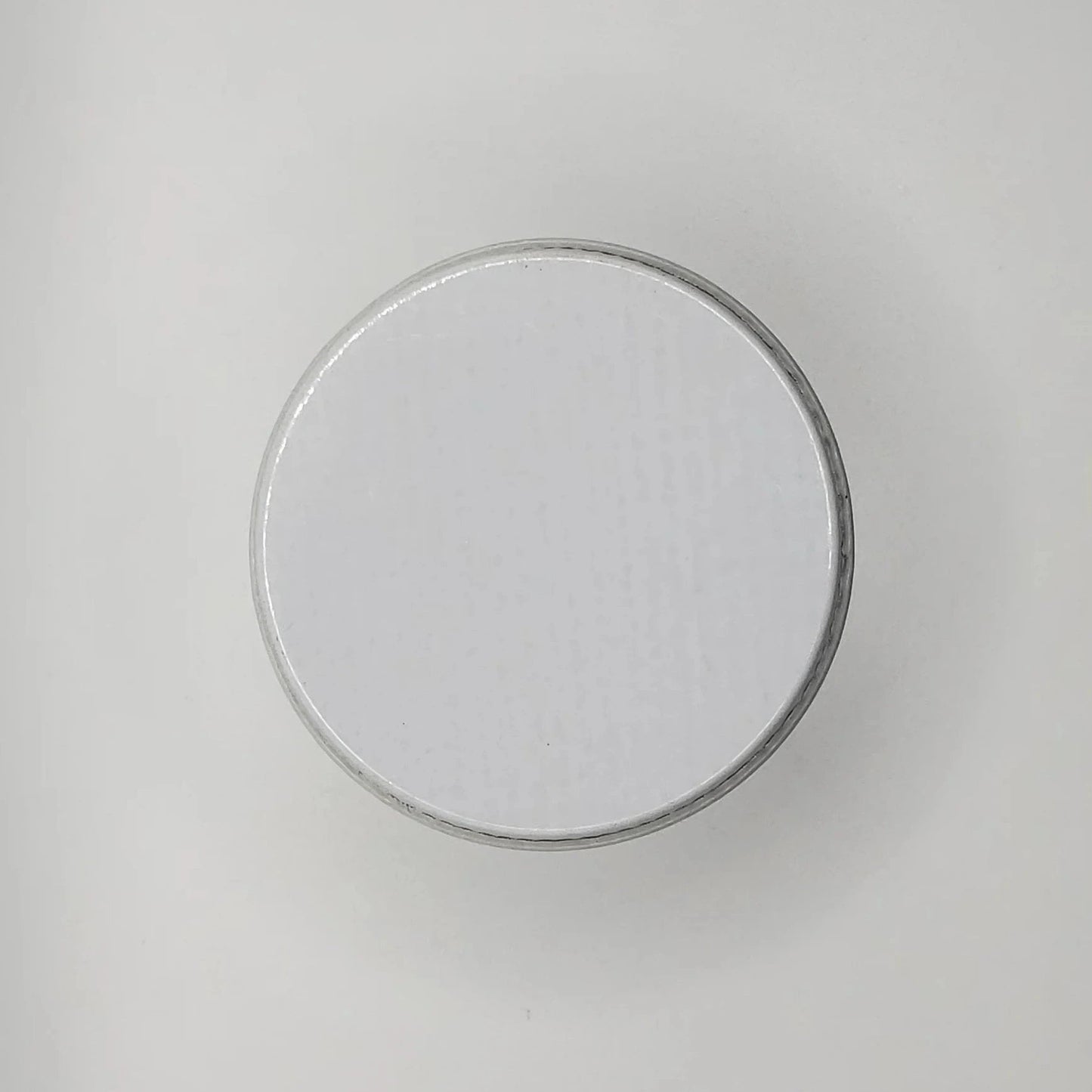 Round white lid on a light gray background