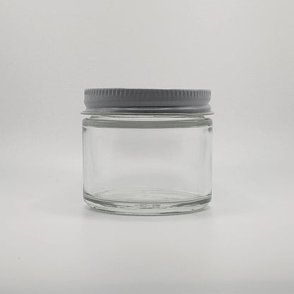 Clear glass jar with a gray lid on a light gray background