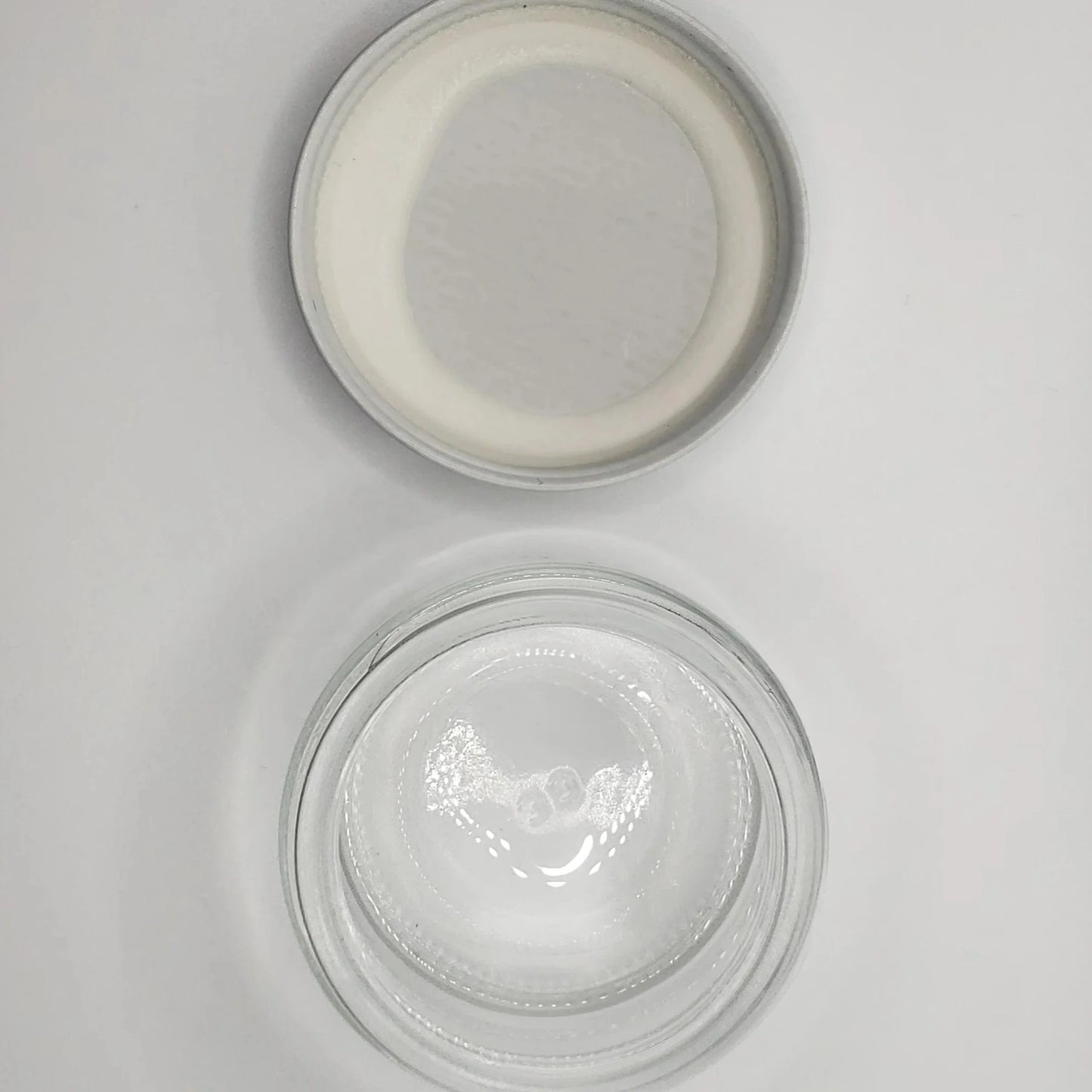 Two glass jars with lids on a light gray background