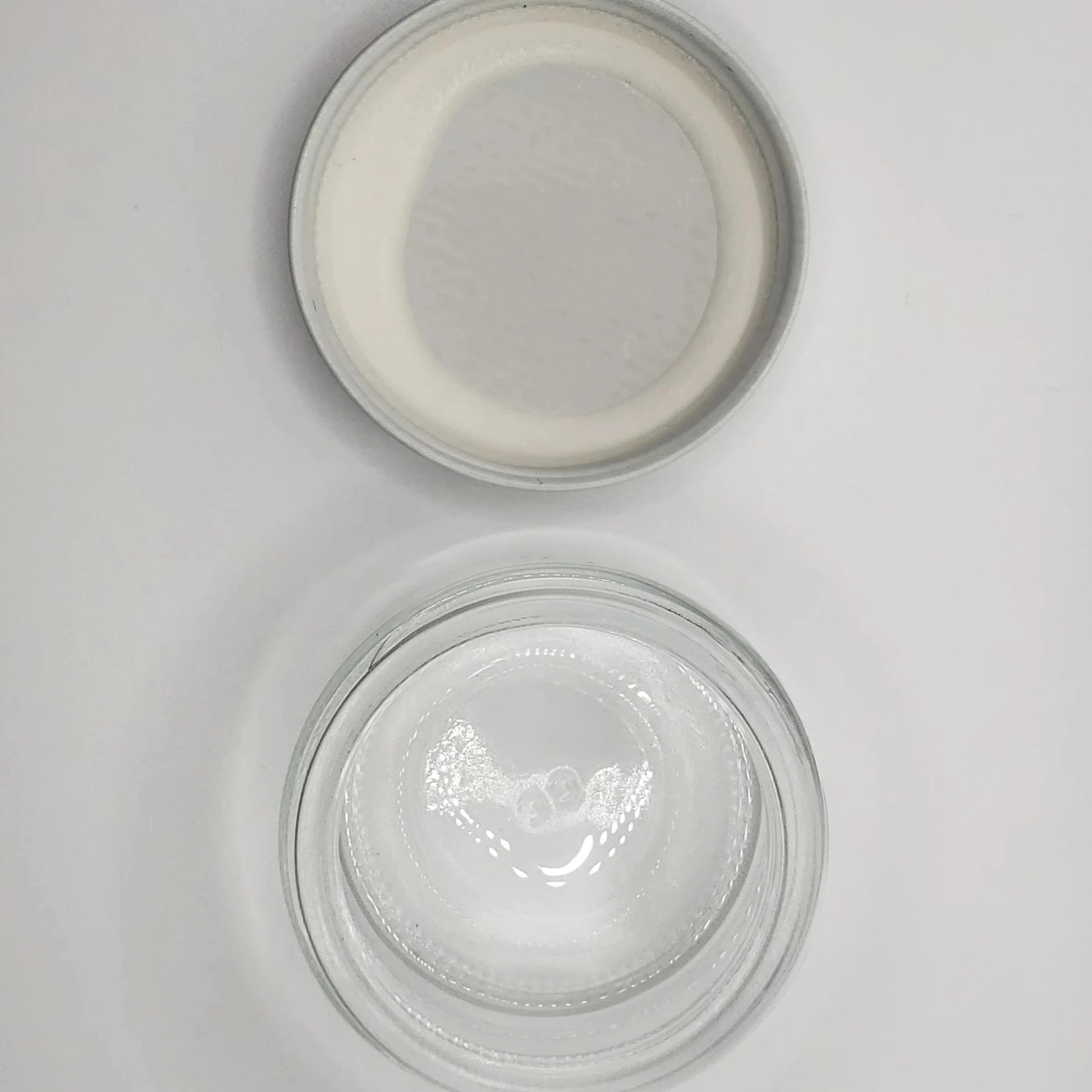 Two glass jars with lids on a light gray background