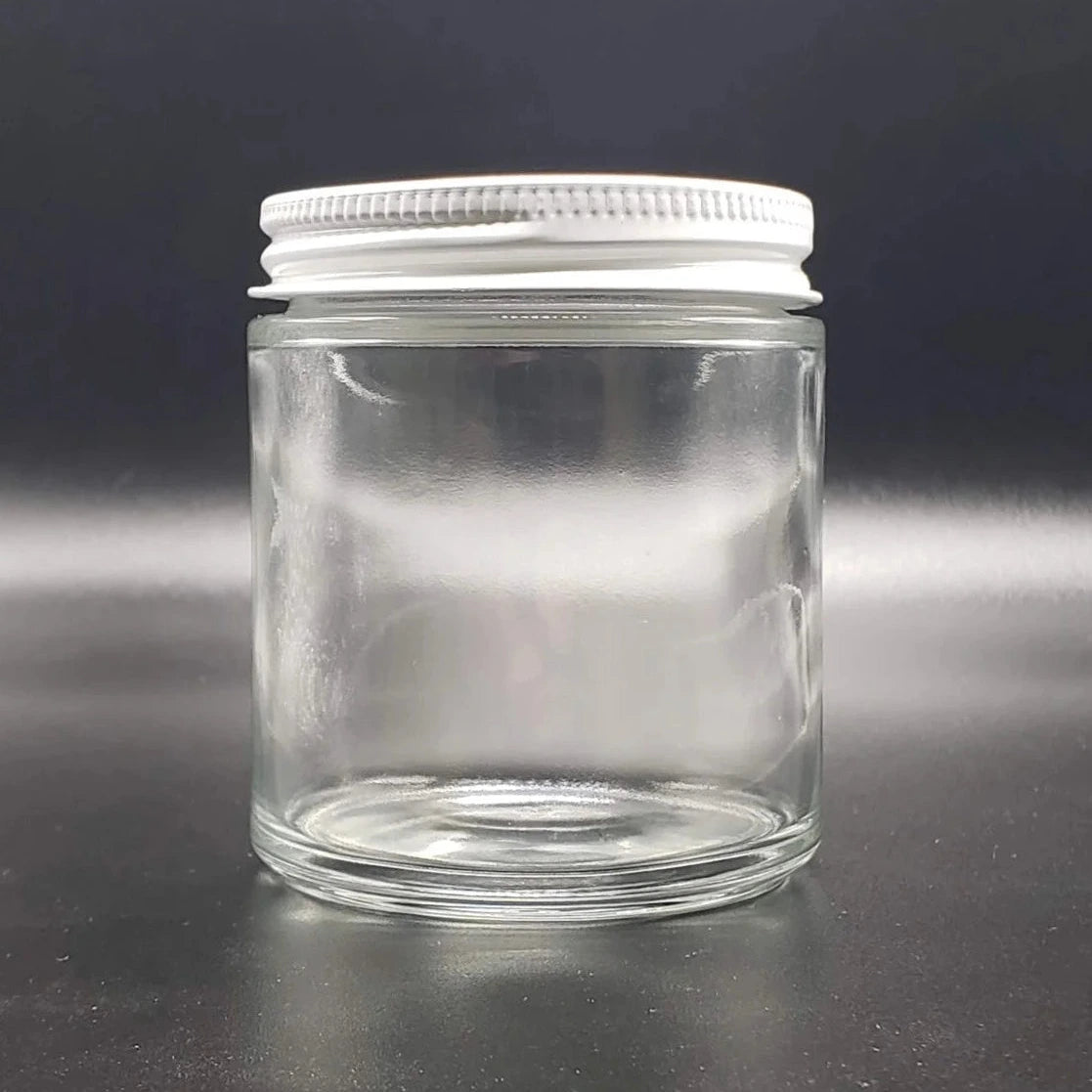 Clear glass jar with a white lid on a black background