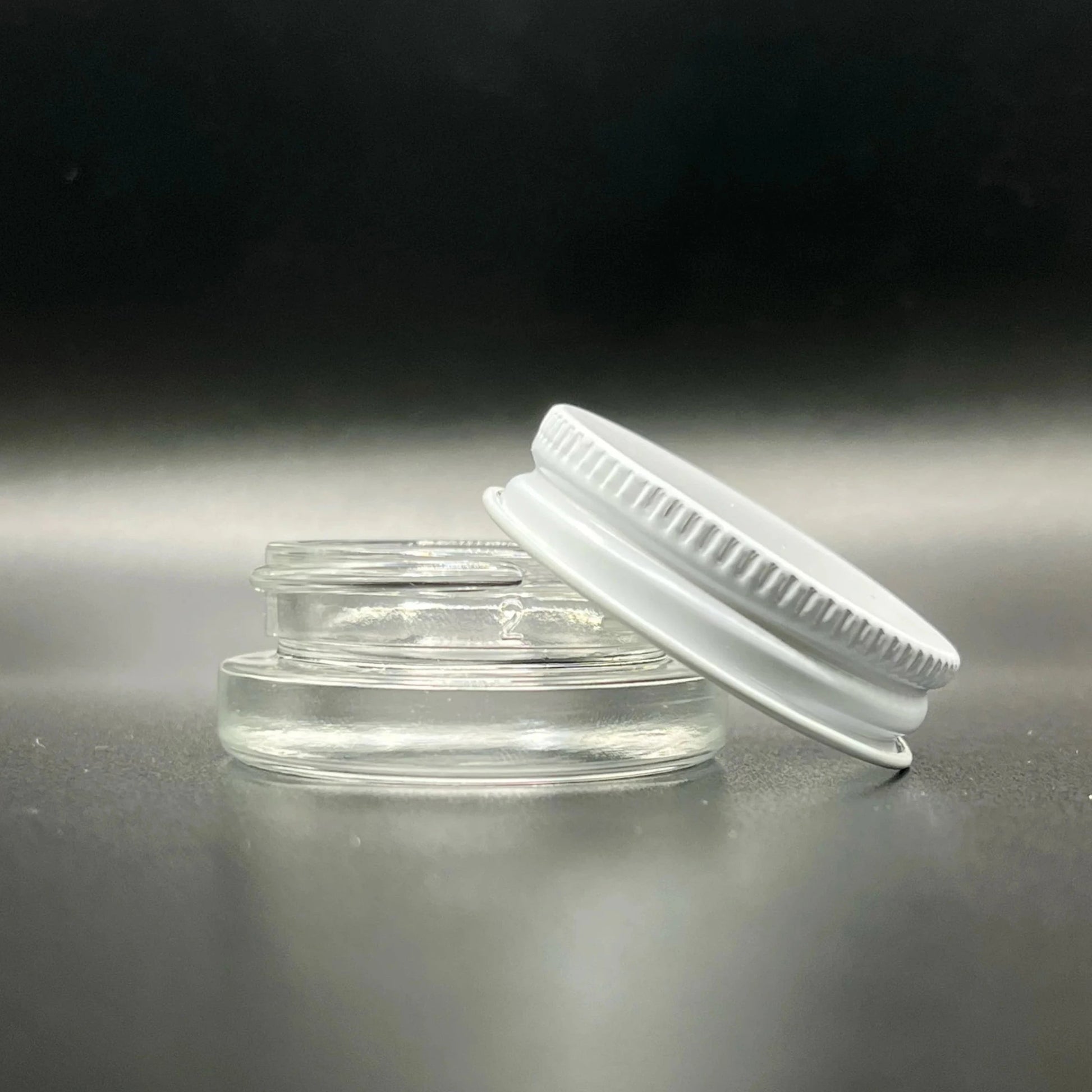 Clear plastic container with a white lid on a reflective surface
