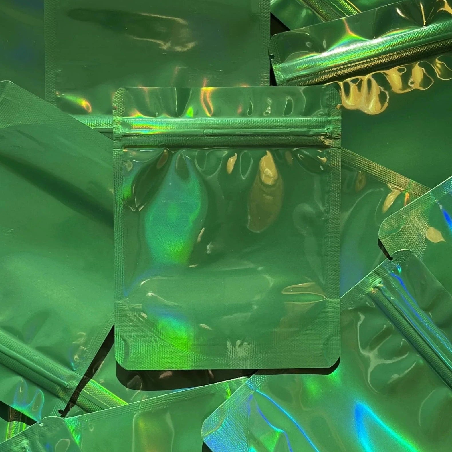 Coffee Shop Green Holographic 4x5 mylar bag on top of mylar