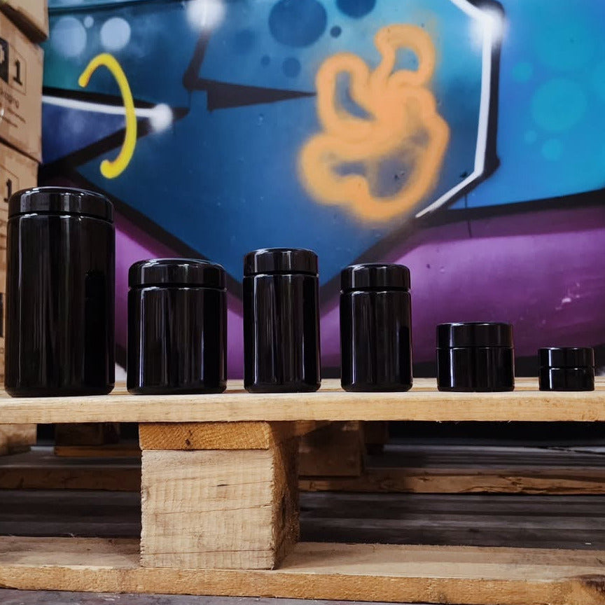 Six round black Miron UV glass jars