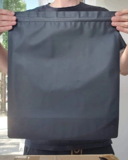 White size P mylar bag held by a hand against a colorful background