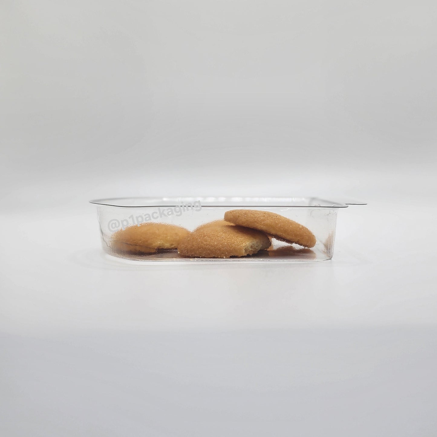 Clear plastic container with cookies on a white background