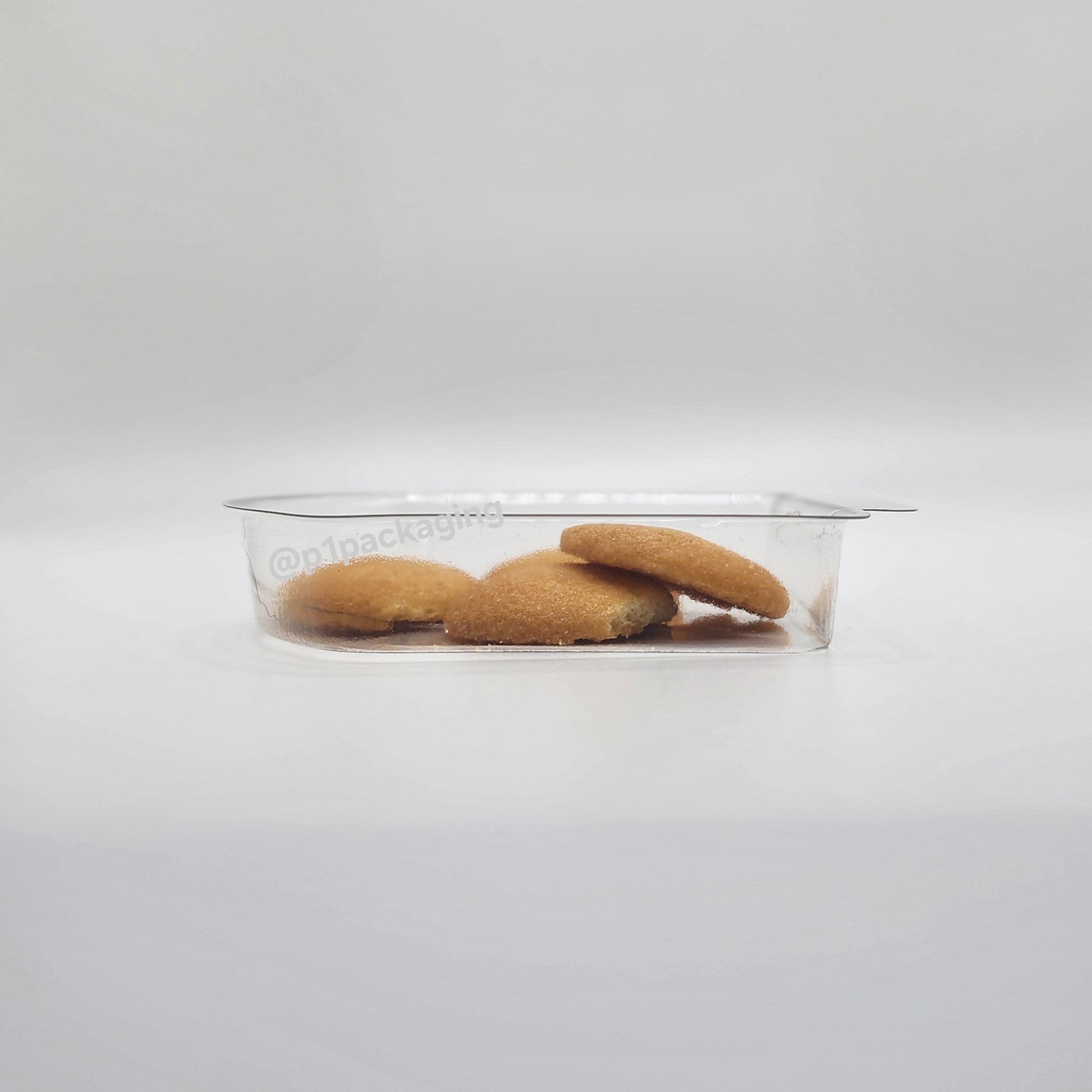 Clear plastic container with cookies on a white background