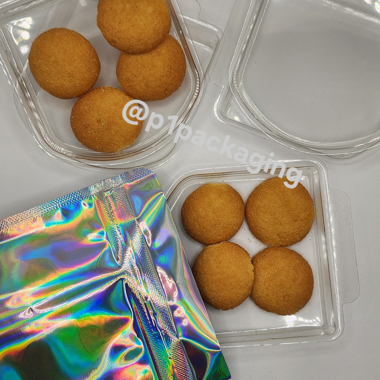 Three plastic trays net to a silver holographic 4x5 mylar bag on a whitebackground