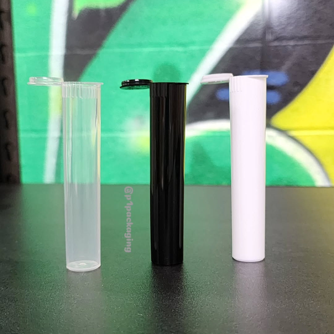 Three cylindrical plastic tubes in clear, black, and white on a reflective surface with a colorful background.