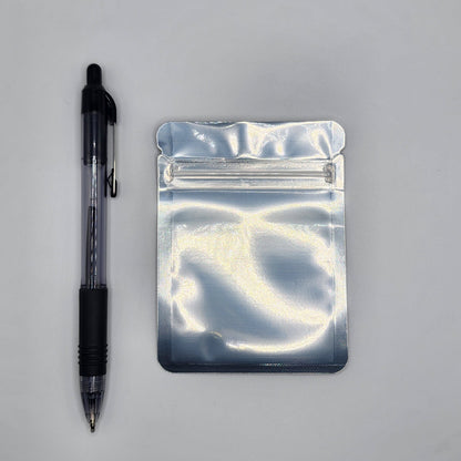 Silver 3x4 mylar bag with a pen on a white background