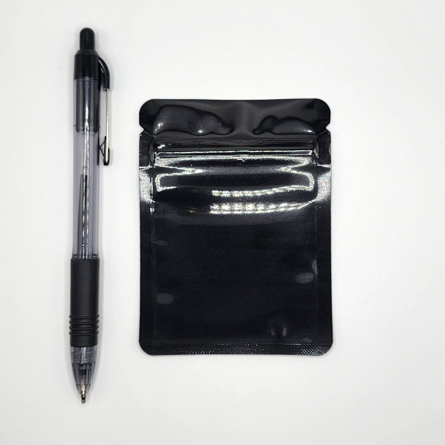 Black 3x4 mylar bag and pen on a white background