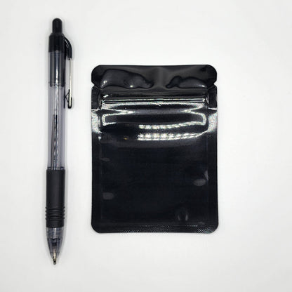 Black 3x4 mylar bag and pen on a white background
