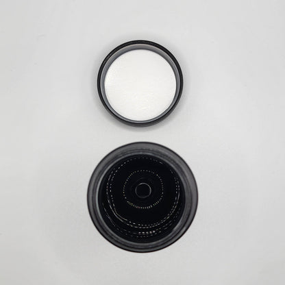 Two black camera lens caps on a light gray background