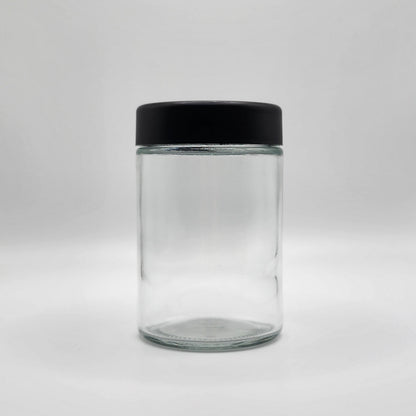 Clear glass jar with a black lid on a white background