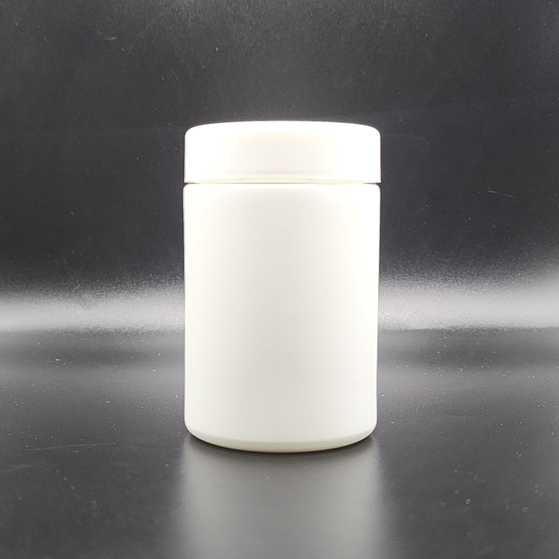White ceramic jar with lid on a black background