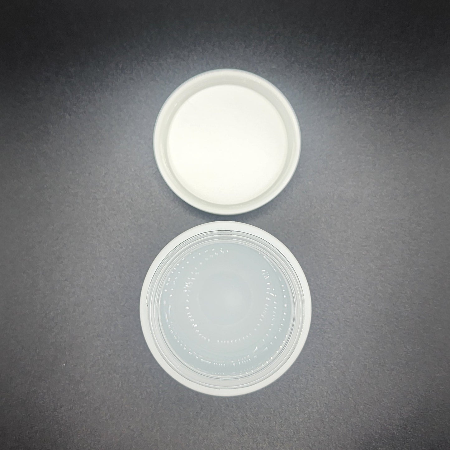 Two plastic lids on a dark gray background