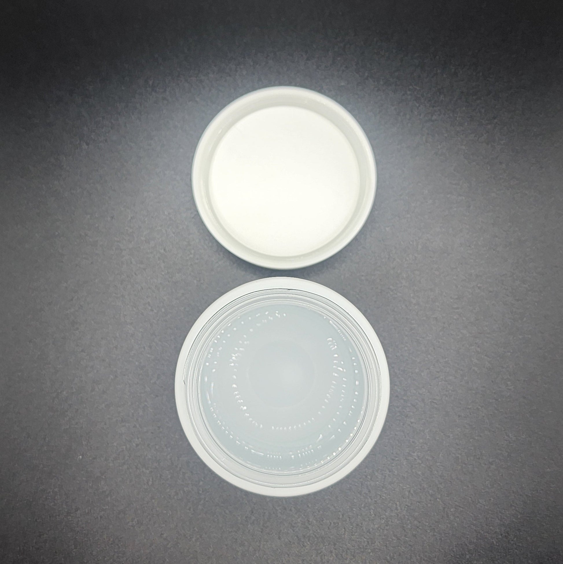 Two plastic lids on a dark gray background