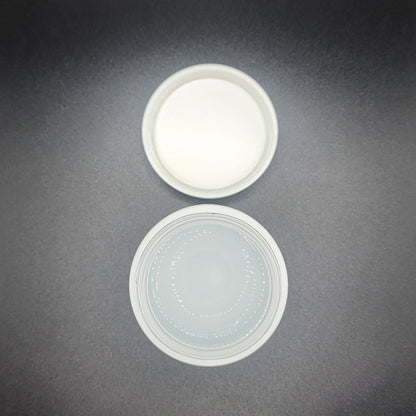 Two plastic lids on a dark gray background