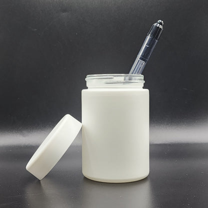 White jar with a pen inside on a black background