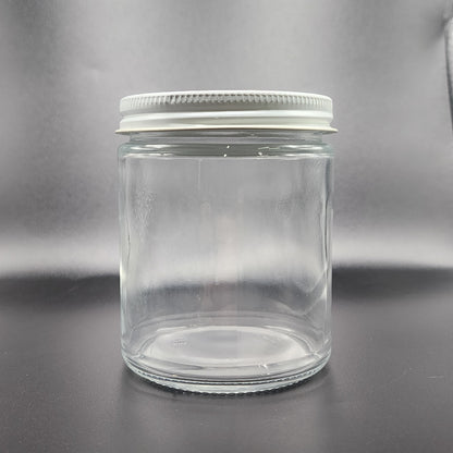 Clear glass jar with a metal lid on a gray background