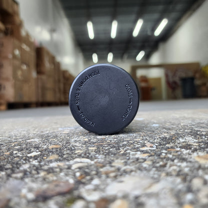 Close-up of a round metal object with text on a textured wall.