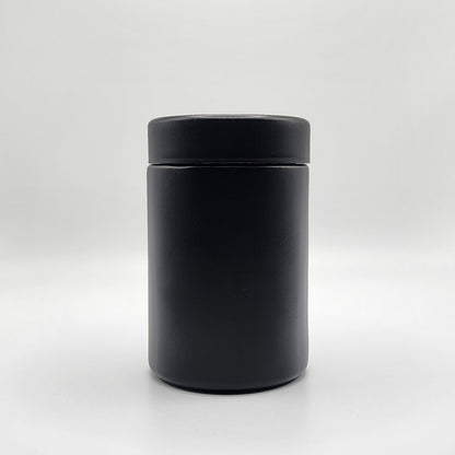 Black cylindrical container with lid on a white background
